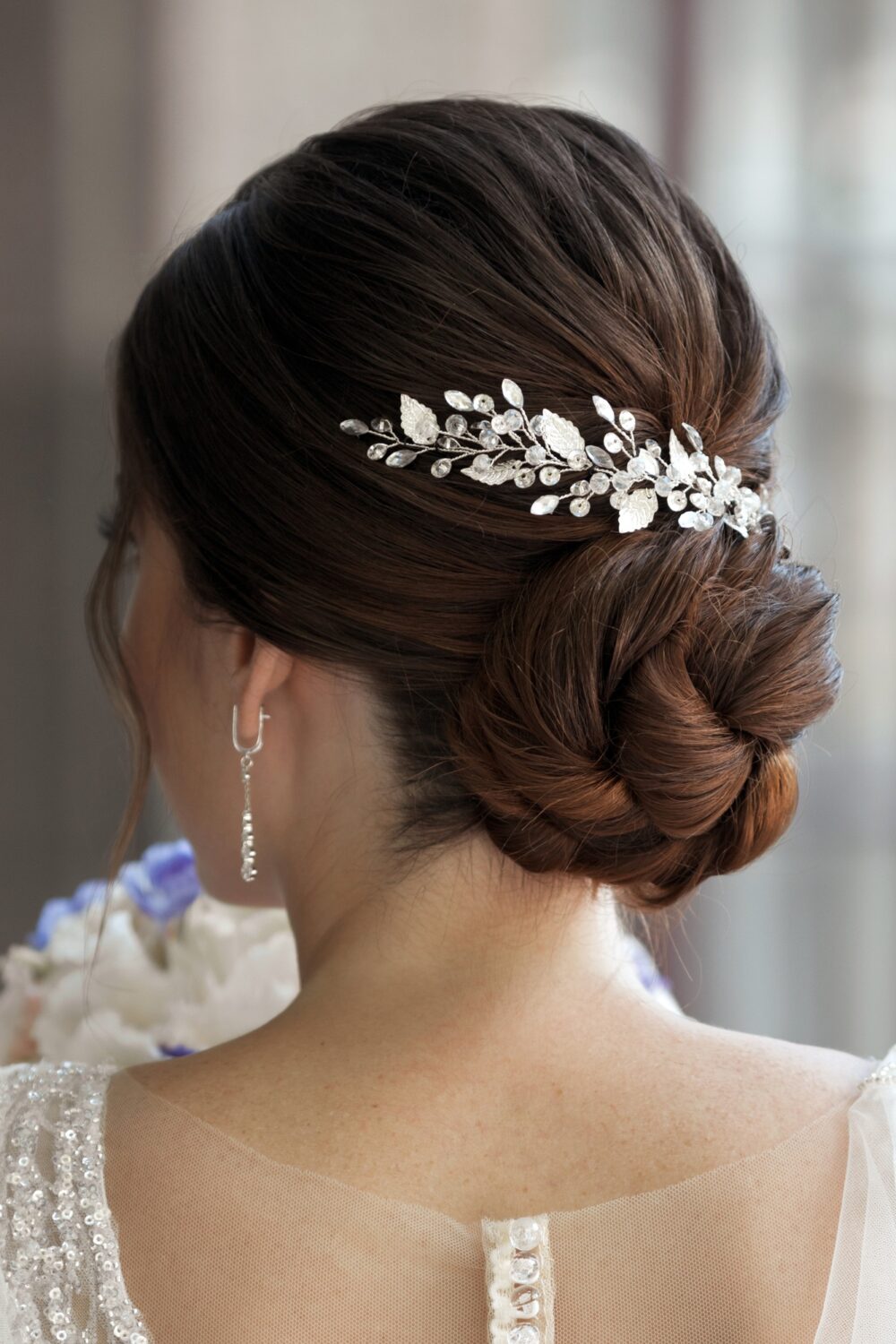 Close-up bride frome back with elegance wedding updo hairstyle for medium brown hair with hairpin