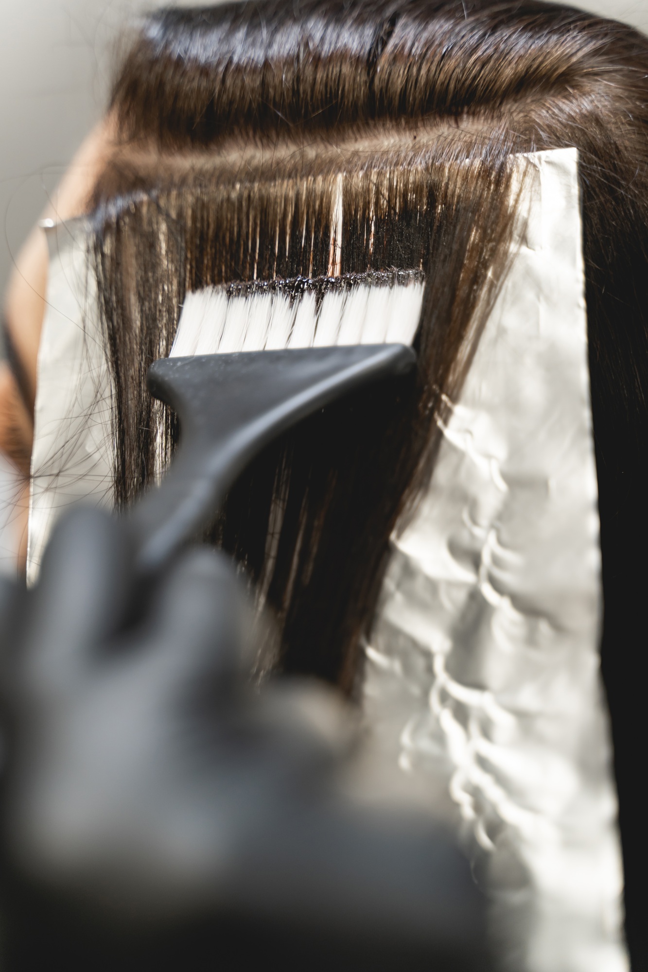 Competent stylist tinting hair of her client